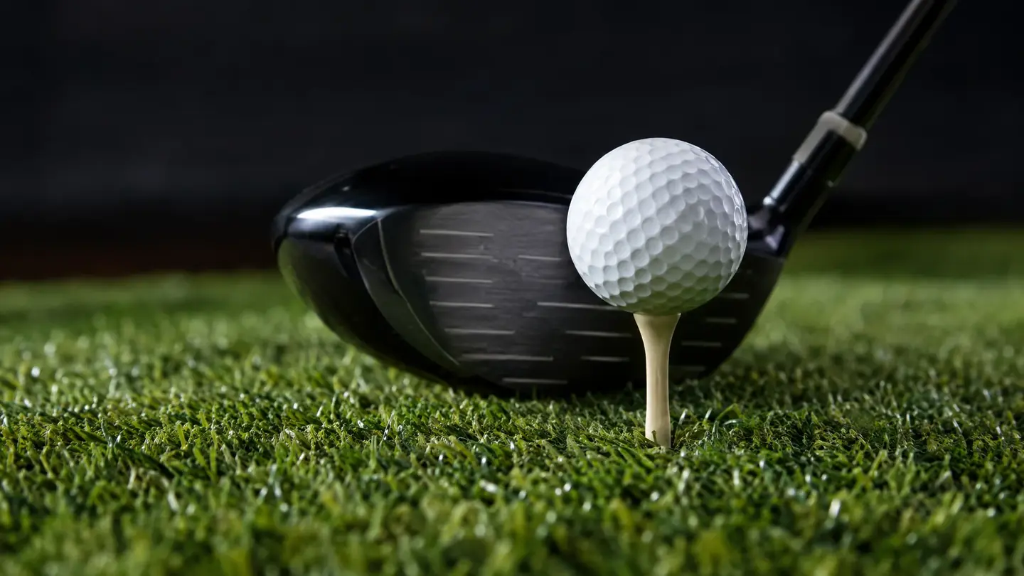 Premium golf hitting mat with a ball on a tee and a driver