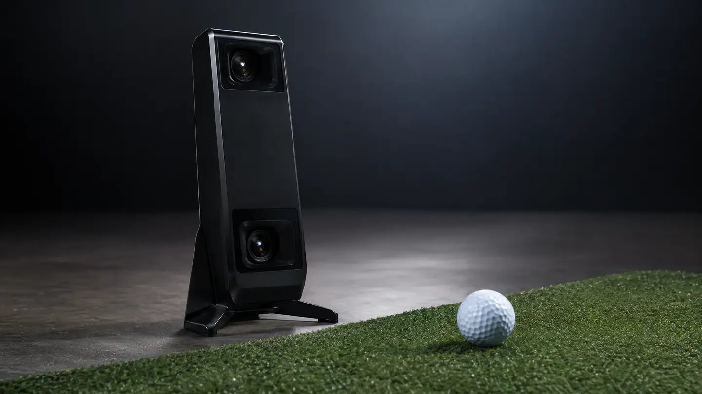 Floor camera launch monitor beside a ball on a hitting mat
